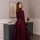 Woman wearing a high-quality-modest maxi dress in burgundy for graduation or special occasions, with puff sleeves and elegant cotton-blend fabric.