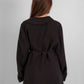 Woman wearing a long sleeve asymmetrical black blouse in luxurious premium fabric, tunic length, modest fashion style.