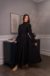 Woman wearing a long sleeve modest maxi dress in black for graduation or special occasions, with puff sleeves and elegant cotton-blend fabric.