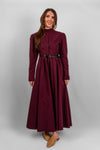Woman wearing a long sleeve modest maxi dress in burgundy for graduation or special occasions, with puff sleeves and elegant cotton-blend fabric.